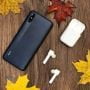 شیائومی Redmi 9i مشکی در کنار هندزفری بلوتوثی
